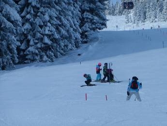 eine Gruppe von Menschen, die mit Skiern einen schneebedeckten Hang hinunterfahren