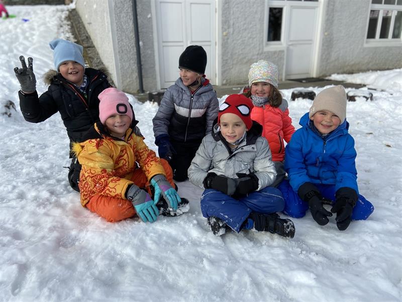 eine Gruppe von Menschen, die im Schnee sitzen