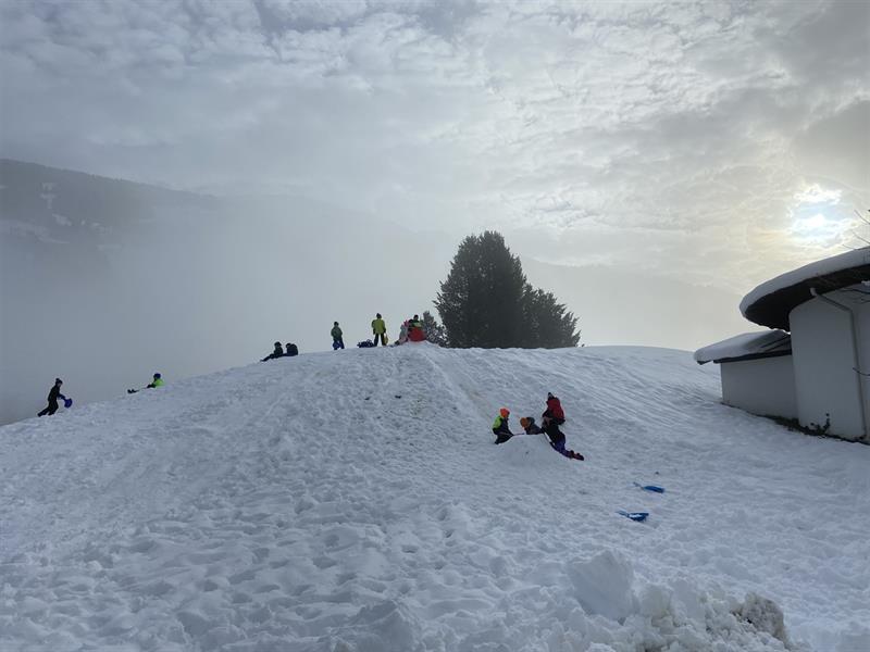 eine Gruppe von Menschen, die auf einem schneebedeckten Hang reiten
