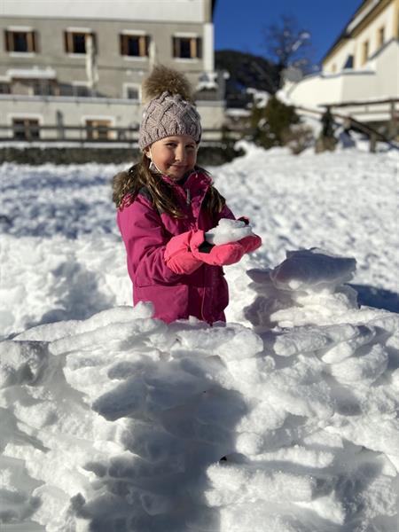 ein kleines Mädchen, das im Schnee sitzt
