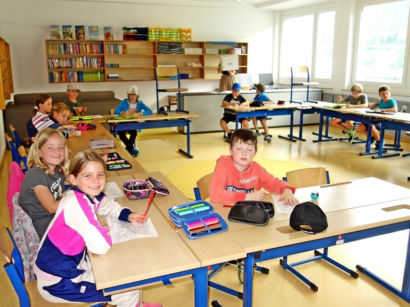 eine Gruppe von Kindern, die an Schreibtischen in einem Klassenzimmer sitzen
