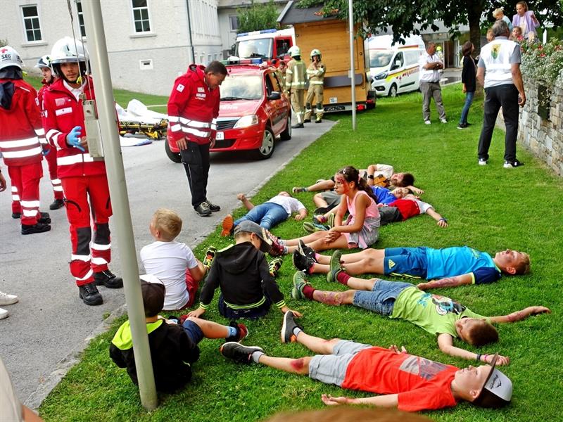 eine Gruppe von Menschen, die mit einer Person in roter Uniform auf dem Boden liegen
