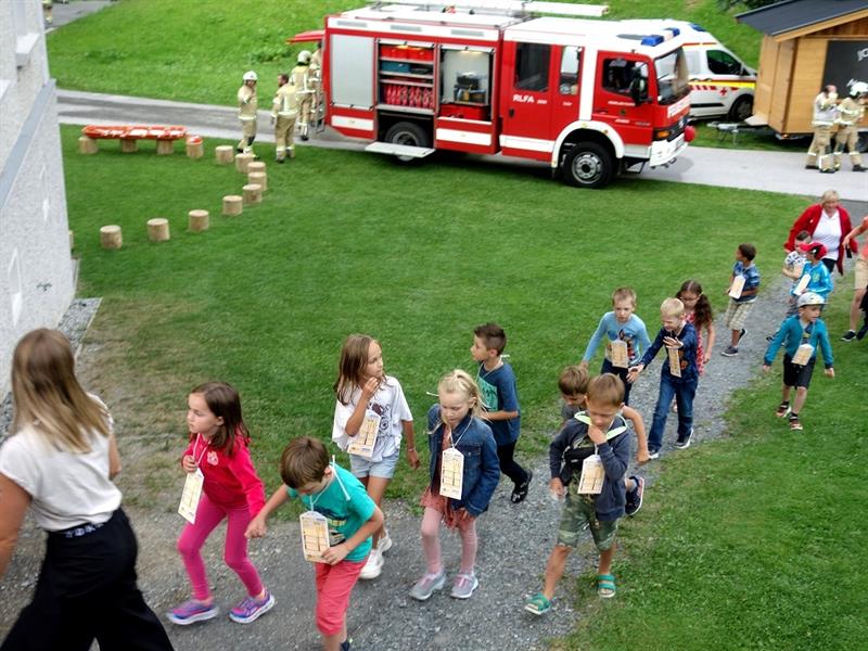 eine Gruppe von Kindern, die vor einem Feuerwehrauto stehen